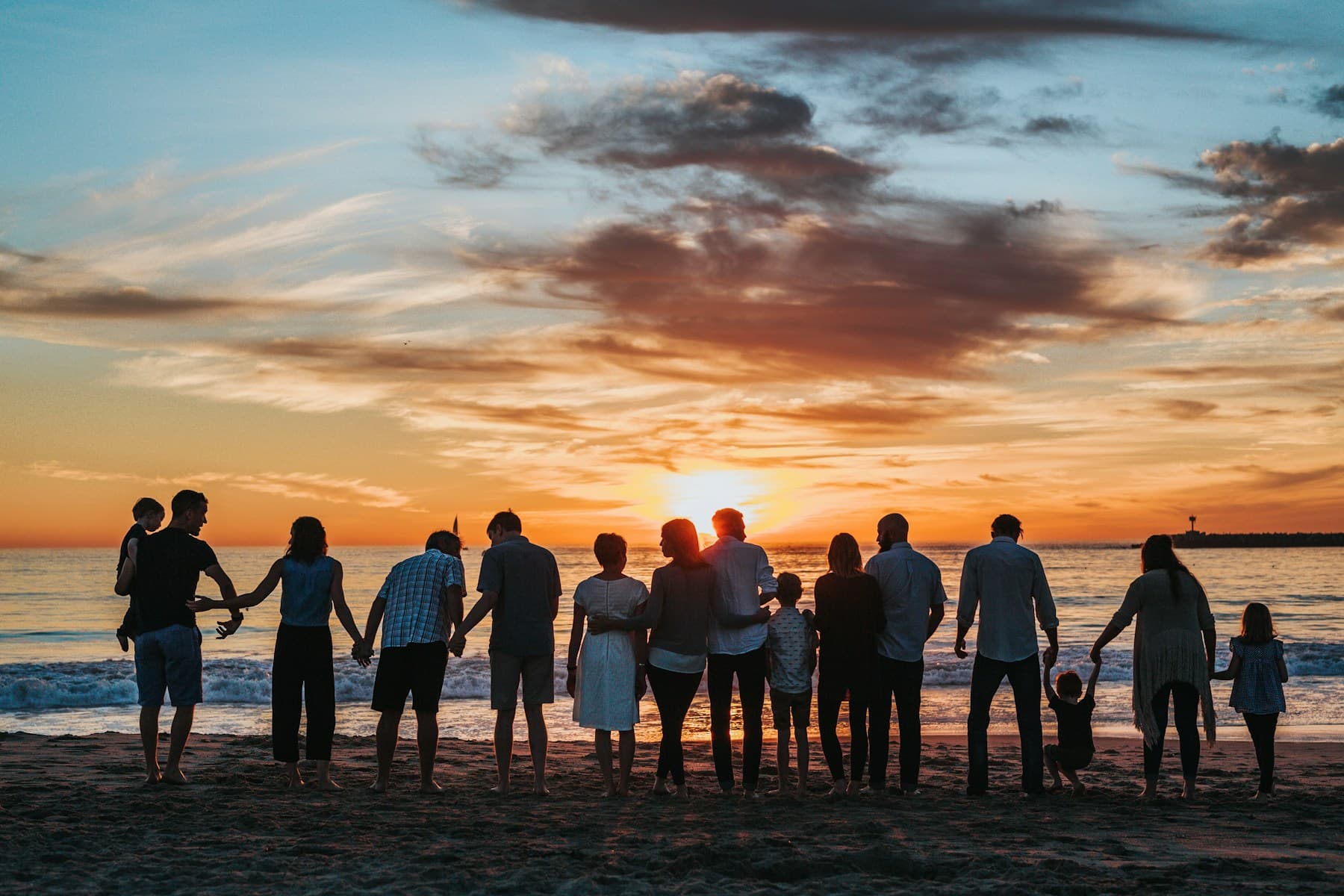 Family group on the beach at sunset for multi-generation villa stay planning